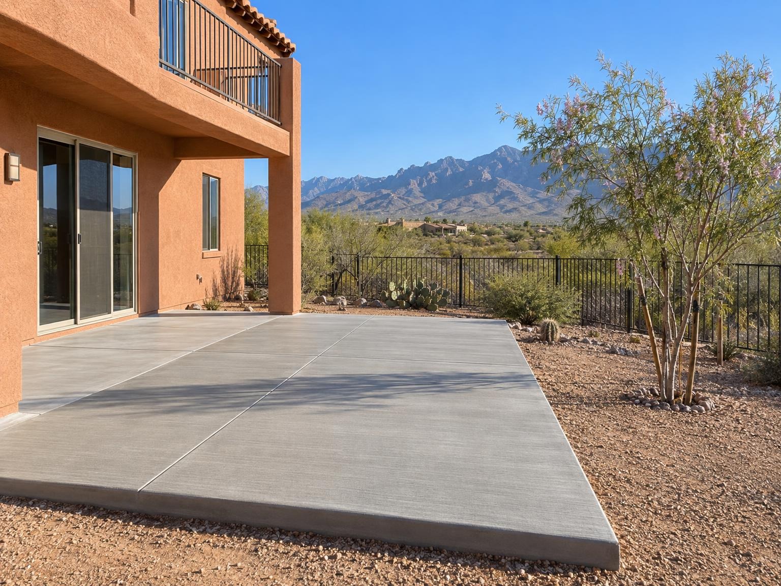 Back patio slab behind a two-story stucco house