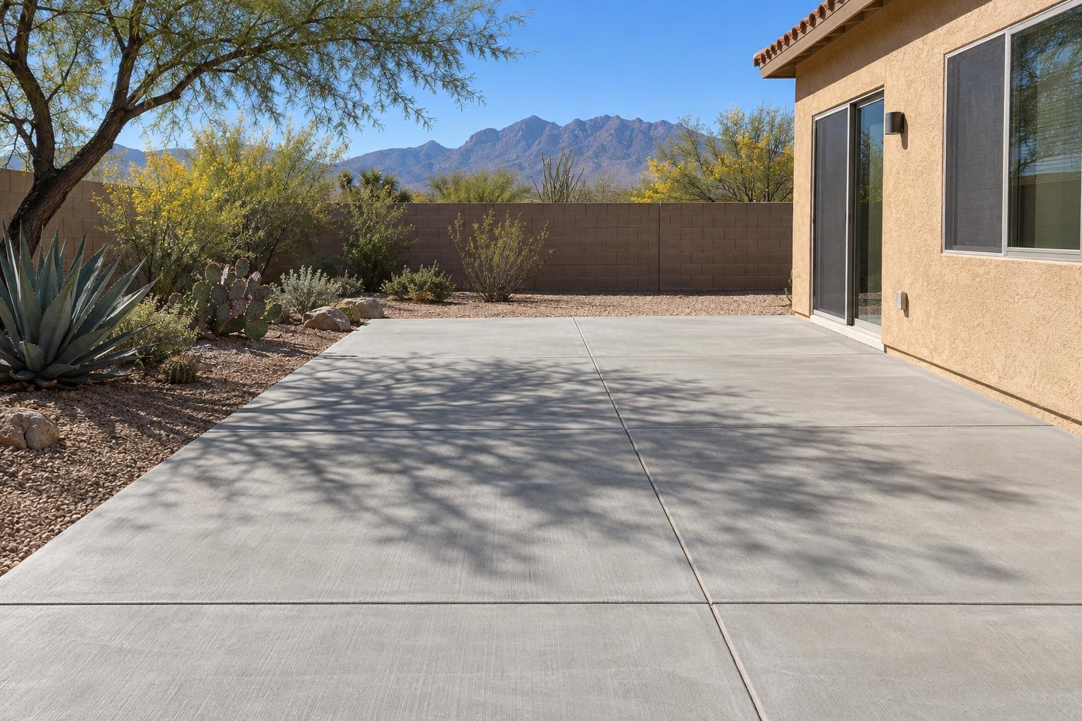 Large patio slab with saw-cut joints beside a desert garden